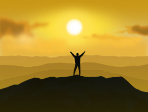 Victorious - Man standing on the top of a mountain with raising